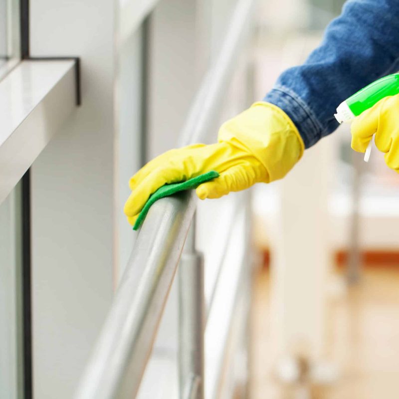 The cleaning lady does the cleaning in the office with a wet cloth.