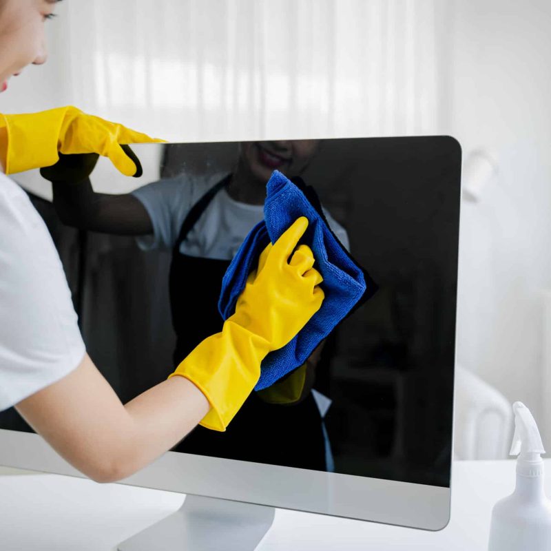 Young woman using a computer cleaning cloth to disinfect the office
office cleaning staff cleaning maid